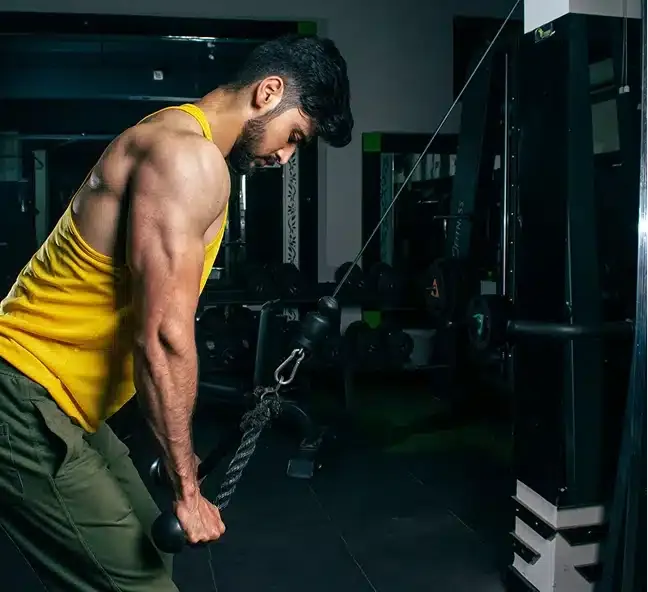 Homem treinando tríceps na polia